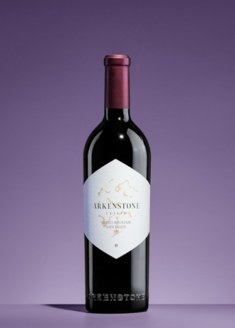 Bouteille de vin Arkenstone, label blanc avec inscriptions dorées, bouchon rouge, arrière-plan violet.