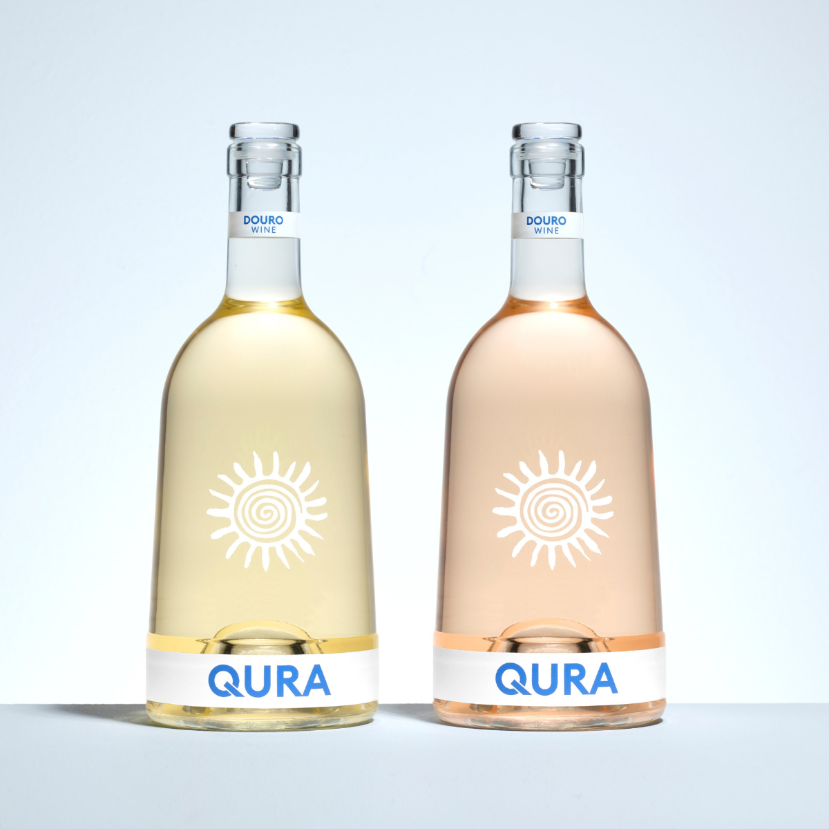 Qura 70 cl. Bouteille au corps élégant et épuré, épaulement haut et col élancé, pour spiritueux. Finition BVS en verre Extra-blanc. Sérigraphie d'un soleil stylisé et du logo QURA.