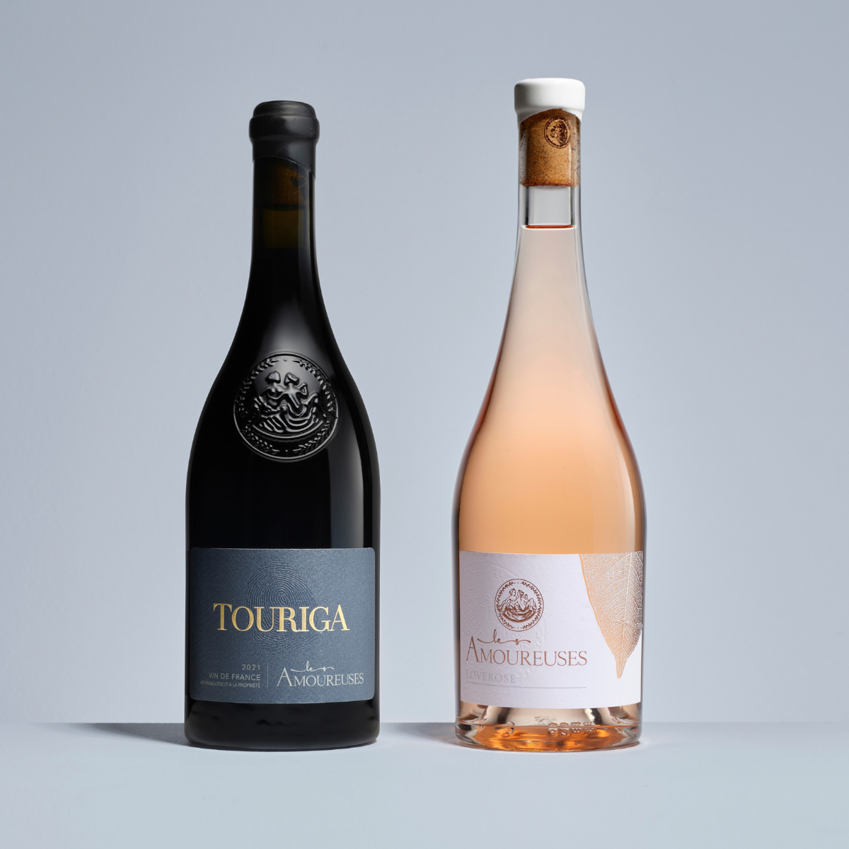 Bourgogne. Bouteille de vin rouge au corps élancé et épaulement marqué, finition Bague standard, teinte Antique. À côté, une bouteille de vin rosé au corps conique et épaulement doux, finition Bague liège, teinte Extra-Blanc.